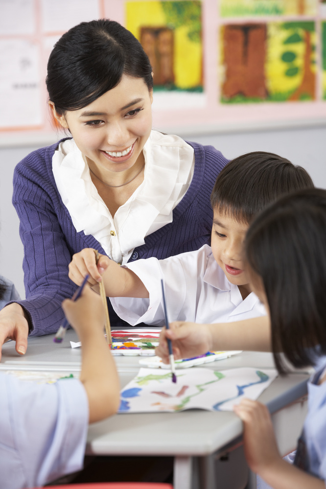 Teacher Helping Students during Art Class in Chinese School Clas